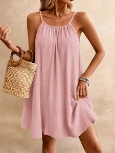 Gros plan d'une robe courte rose sans manches avec un tissu texturé très ample.