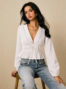 Detailed view of white deep V-neck blouse featuring delicate lace trim and peplum waist