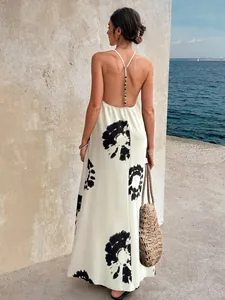 Elegant backless white maxi dress with black tie-dye floral print and beaded strap detail.