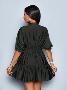 Back view of a stylish black puff sleeve mini dress with ruffled hem and elastic waist.