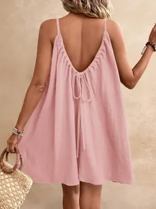 Vue de dos d'une robe rose sans manches avec dos nu en V et détail de nœud à nouer.