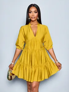 Elegant mustard yellow tiered mini dress with deep V-neck and puff sleeves detail view