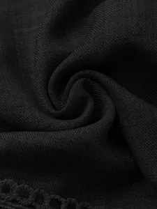 Macro della texture a coste fini e del bordo in pizzo del tessuto dell'abito nero elegante.