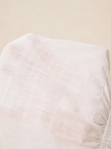 Macro detail of breathable white woven fabric texture showing the fine weave quality