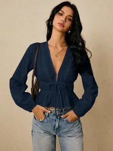 Detailed shot of the deep V-neck blouse with hollow lace trim and cinched tie waist.