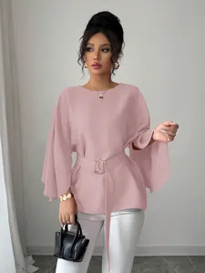 Detail of a pink French vintage blouse featuring flared sleeves and a belted waist