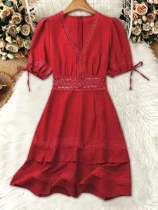 Dettaglio elegante vestito rosso scollo a V con vita in pizzo e maniche a sbuffo