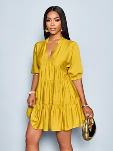 Close-up of mustard yellow V-neck tiered mini dress with elegant puff sleeves