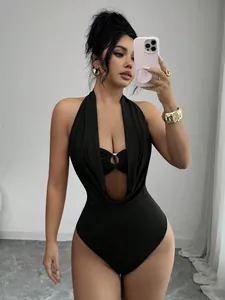Detail shot of a sexy black halter neck bodysuit with deep V cutout and central ring.