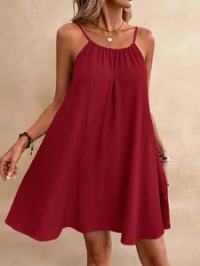 Détail d'une mini-robe rouge sans manches en tissu gaufré avec une encolure dos nu chic