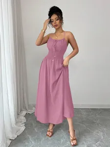Elegant pink sleeveless maxi dress with a smocked waist and delicate spaghetti straps.