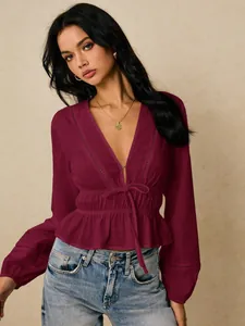 Detailed view of the deep V-neck lace hollow blouse with ruffled hem and tie waist