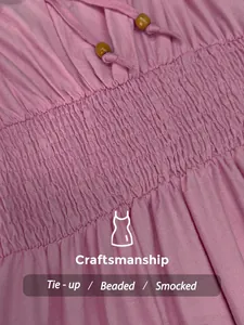 Macro view of pink smocked dress craftsmanship showing tie-up beaded drawstring detail