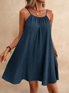 Gros plan d'une robe courte bleu marine sans manches en tissu gaufré fluide.