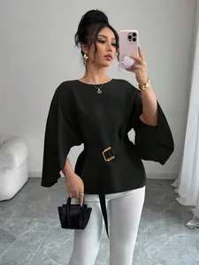 Detail view of a French retro black blouse with elegant flared sleeves and a gold belt.