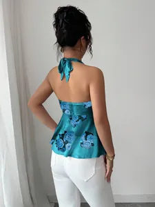 Vista trasera de un top halter floral turquesa con detalle de lazo y dobladillo peplum.