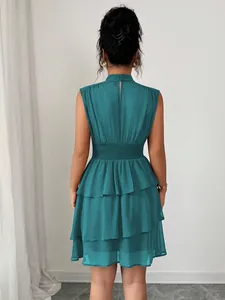 Vista posteriore di un elegante abito corto a balze senza maniche color petrolio e collo.