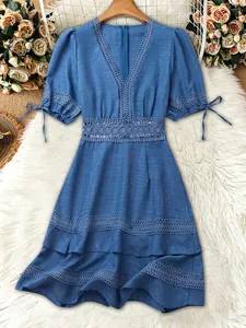 Dettaglio dell'abito blu con scollo a V, pizzo intricato e graziose maniche a sbuffo