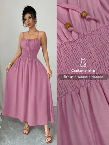 Detailed view showing the smocked waist and beaded tie-up design of the mauve dress