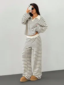 Vista intera di una donna con completo in maglia a righe con scollo a V e pantaloni larghi