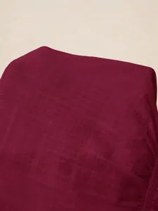 Close-up of the burgundy linen-like fabric texture showing detailed woven patterns