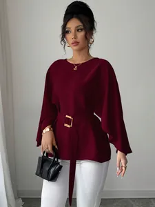 Close-up detail of burgundy French retro bell sleeve top with adjustable gold buckle belt