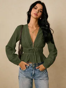 Close-up of olive green V-neck ruffle blouse with delicate lace trim and tie waist