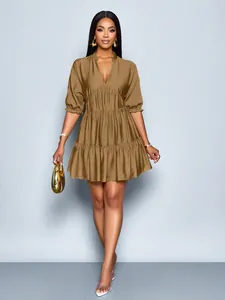 Elegant brown tiered mini dress on a model with ruffled puff sleeves and V-neck.