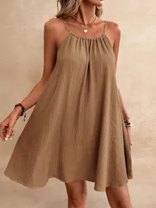 Détail de la mini-robe licou marron bohème avec un tissu texturé et une coupe d'été ample