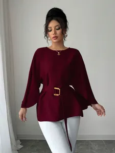 Detailed view of French retro maroon top with flared sleeves and gold buckle belt