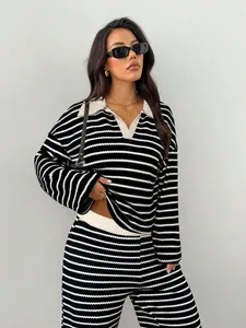 Dettaglio del set in maglia a righe bianche e nere con top a maniche lunghe e pantaloni.