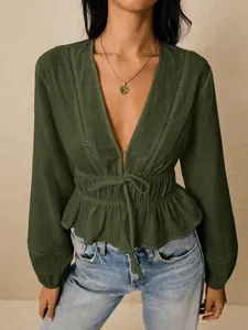 Close-up of deep V-neck blouse with adjustable waist tie and ruffle hem detail