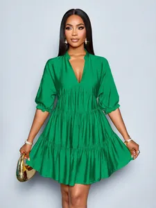 Elegant emerald green mini dress featuring a deep V-neck and tiered pleated design