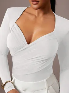Dettaglio di un body in velluto bianco con scollo a V e design incrociato arricciato