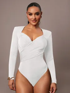 Dettaglio di un elegante body in velluto bianco a maniche lunghe con scollo a V