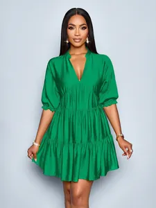 Elegant emerald green tiered mini dress with deep V-neck and puff sleeves detail