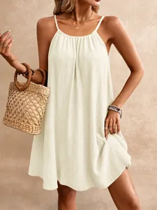 Vue détaillée de l'élégante mini-robe dos nu crème avec une texture de tissu gaufré