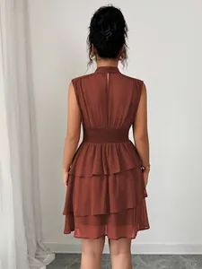 Vista posteriore di un mini abito smanicato ruggine con gonna a balze e vita elastica.