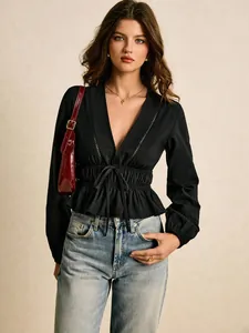 Elegant black deep V-neck blouse with lace details and ruffle hem on a fashion model