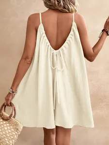 Détail du dos d'une mini robe écrue dos nu avec lien à nouer et tissu texturé bohème