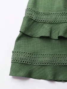 Dettaglio ravvicinato di un abito verde con finiture in pizzo e balze a strati eleganti