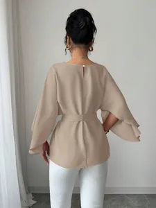 Back view of a French vintage beige blouse with elegant flared sleeves and round neck.