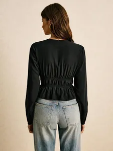 Detailed back view of a black long sleeve peplum blouse featuring an elastic waist