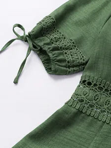 Primo piano di manica a sbuffo verde con pizzo delicato e dettaglio di fiocco decorativo