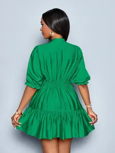 Rear view of vibrant green pleated mini dress with puff sleeves and ruffled hem