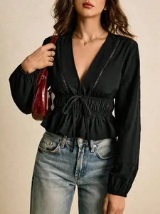 Close-up of black deep V-neck blouse with lace trim and ruffled peplum hem
