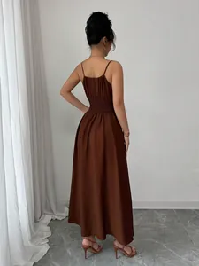 Back detail view of a brown sleeveless sundress featuring a smocked waist and thin straps