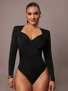 Dettaglio di un body in velluto nero con scollo a V incrociato e design a pieghe elegante