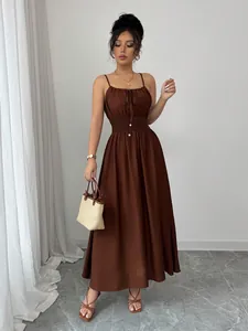 Detail of a brown sleeveless maxi dress with a smocked waist and tie-front detail.