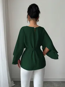 Back view of an elegant French vintage green blouse with flared sleeves and belted waist